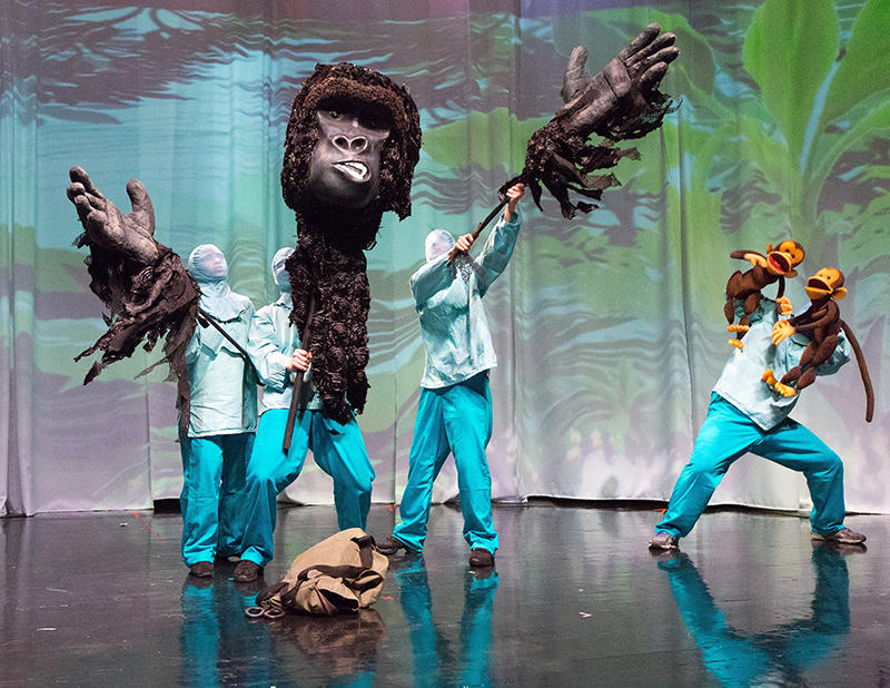 Three puppeteers operate a large gorilla puppet, interacting with another puppeteer operating smaller monkey puppets in Enchantment Theatre Company's My Father's Dragon.
