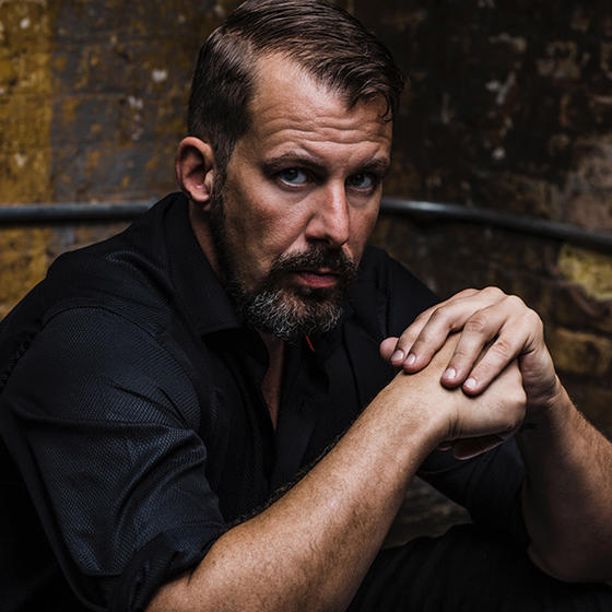 Headshot of Baritone Kyle Albertson in a black shirt.