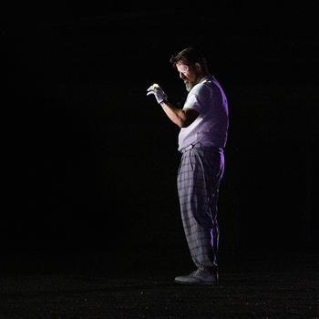 Baritone Kyle Albertson as the one-eyed king of the gods Wotan, in Wagner's "Das Rheingold," wears an eye patch, white shirt, plaid golf pants, and gloves, in the 2021 Virginia Opera production at the unique venue of Topgolf.
