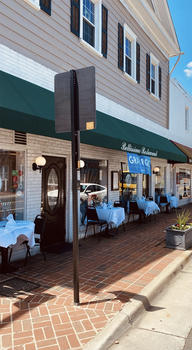 The gray brick and siding exterior of Bellissimo restaurant, located on historic Main Street in Olde Town Fairfax, VA.